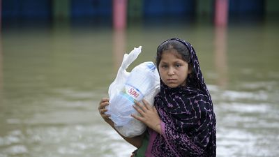 طفلة بنغالية تحمل مواد إغاثة في منطقة كومبانيغونج في سيلهيت التي تضررت بفعل الفيضانات،  20 يونيو 2022.