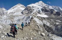 Trekkers pass through a glacier at the Mount Everest base camp, Nepal.