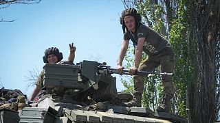 A Ukrainian soldier smiles as he shows a victory-sign atop a tank in Donetsk region, Ukraine, Monday, June 20, 2022.