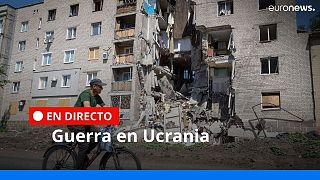 Un hombre pasa en bicicleta por delante de un edificio dañado por los bombardeos rusos en Bakhmut, región de Donetsk, Ucrania, el lunes 20 de junio de 2022.