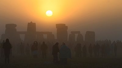 Revellers gather to celebrate the Summer Solstice at sunrise at Stonehenge stone circle near Amesbury