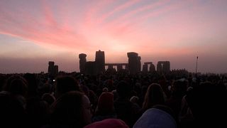 Sun rises behind Stonehenge on summer solstice