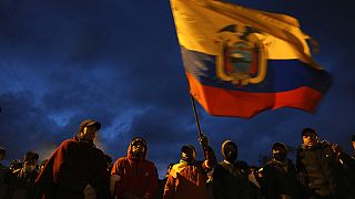 Manifestantes indígenas ondean una bandera de Ecuador en la capital, Quito