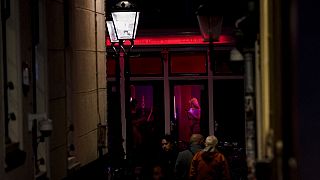 Prostitutas y transeúntes en el Barrio Rojo de Ámsterdam.