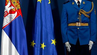 A member of the Serbian honour guard stands by Serbian, left, and EU flags during visit of Greek President Prokopis Pavlopoulos in Belgrade, Serbia, Oct. 2, 2017. 