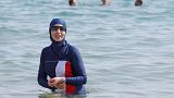 Karima, wearing a full-body burkini swimsuit, swims in Cannes after the call to support the wearing of burkinis by businessman and political activist Rachid Nekkaz.