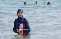 Karima, wearing a full-body burkini swimsuit, swims in Cannes after the call to support the wearing of burkinis by businessman and political activist Rachid Nekkaz.