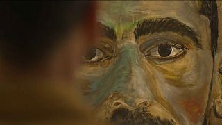  الرسام مصطفى عظيميتابار ينظر إلى إحدى لوحاته