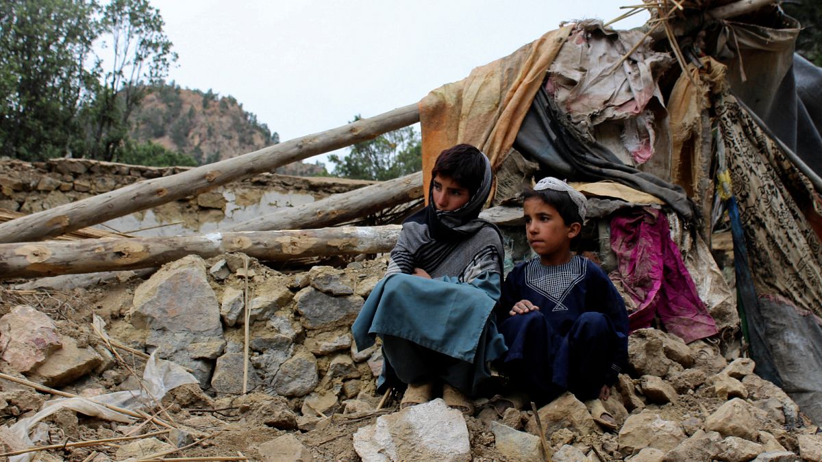Crianças afegãs sobre as ruínas da casa onde viviam antes do terramoto