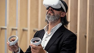 An attendee tries out a Meta virtual reality headset during the Vivatech technology startups and innovation fair in Paris on May 15, 2022.