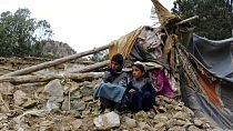 Дети сидят на руинах разрушенного при землетрясении дома в афганской провинции Хост. 22 июня 2022 г.