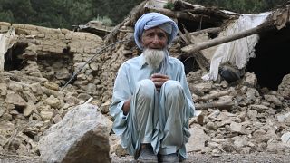 رجل أفغاني يجلس على أنقاض منزله المدمر جراء الزلزال في باكتيا كوت في شرق أفغانستان