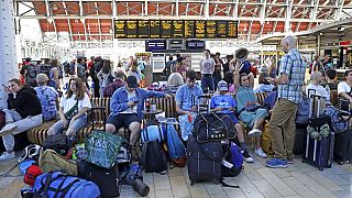 Vasútállomáson várakozó emberek az Egyesült Királyságban