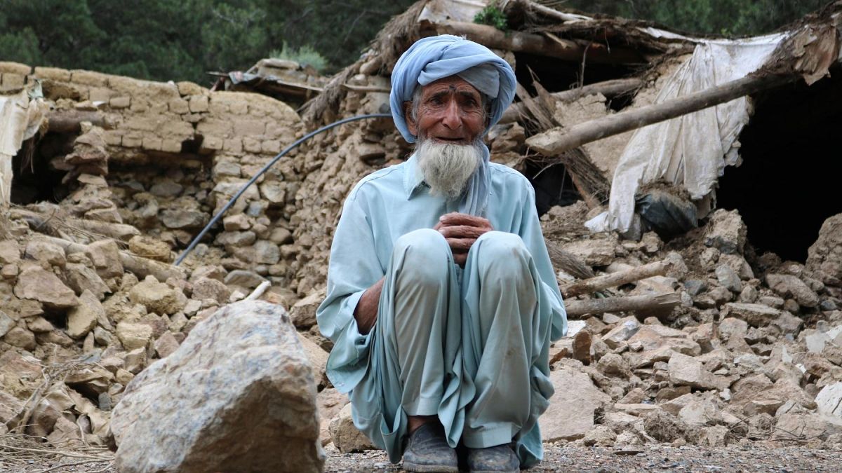 An Afghan man sits near his house that was destroyed in an earthquake in the Spera District of the southwestern part of Khost Province, Afghanistan, Wednesday, June 22, 2022