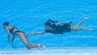 A member of Team USA (R) recovers USA's Anita Alvarez (L), from the bottom of the pool during an incendent in the women's solo free artistic swimming finals