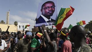 Demonstranten halten Plakate mit einem Photo des Oppositionellen Ousmane Sonko