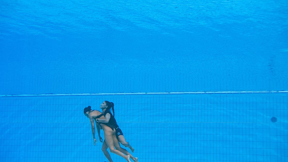 المدربة أندريا فوينتيس تمسك تحت الماء بالسباحة الأمريكية أنيتا ألفاريز.