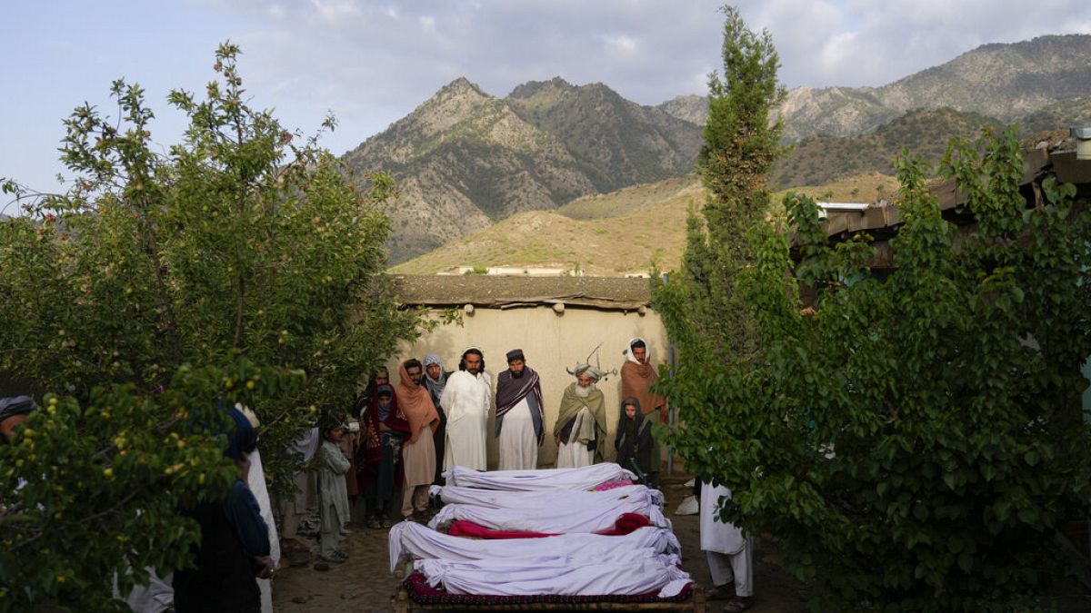 Men stand around the bodies of people killed in an earthquake in Gayan village, in Paktika province, Afghanistan