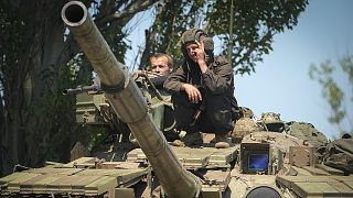 A Ukrainian soldier flashes the victory sign atop a tank in Donetsk region, 20 June 2022