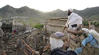 A man stands among destruction after an earthquake in Gayan village