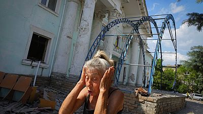 Mulher tapa os ouvidos para não ouvir bombardeamentos russos, em Lysychansk, no Donbass, Ucrânia