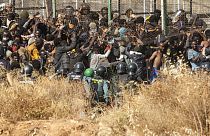 Migrants arrive on Spanish ground after crossing the fences separating the Spanish enclave of Melilla from Morocco in Melilla
