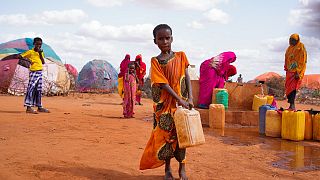 10-year-old Hibo carries water in a jerrycan to her temporary house in Dollow, Somalia, May 24, 2022. Her family left their home and walked for 10 days to reach Kaharey camp.