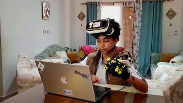 Image shows Omar Wael, 13, demonstrating the sensory glove that he has built for the metaverse he is creating.