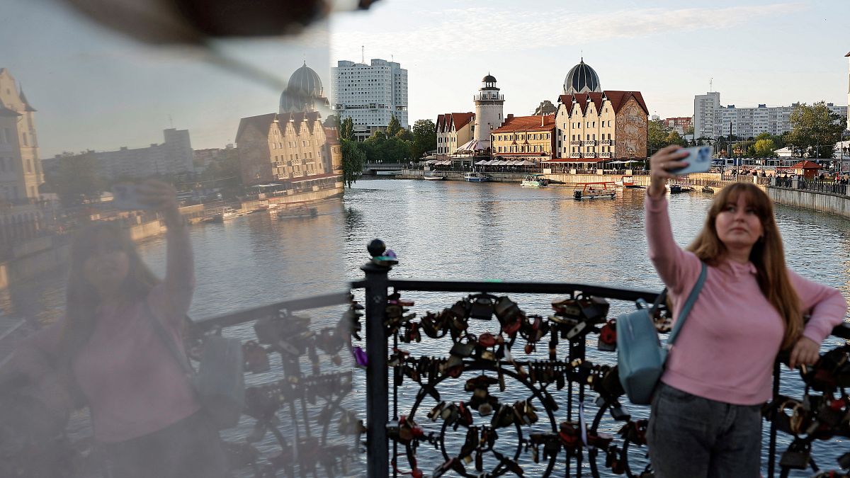 Eine Frau schießt ein Foto am Fluss Pregel in Kaliningrad