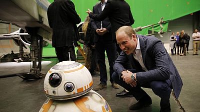 Britain's Prince William, Duke of Cambridge smiles at BB-8 droid during a tour of the Star Wars sets at Pinewood studios in Iver Heath, west of London on April 19, 2016.