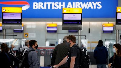 Passengers stand in a queue to the British Airways check-in desks in the departures area of Terminal 5 at Heathrow Airport.