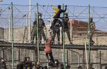 Migrants climb the fences separating the Spanish enclave of Melilla from Morocco in Melilla, Spain, Friday, June 24, 2022.