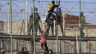 Migrants climb the fences separating the Spanish enclave of Melilla from Morocco in Melilla, Spain, Friday, June 24, 2022. 