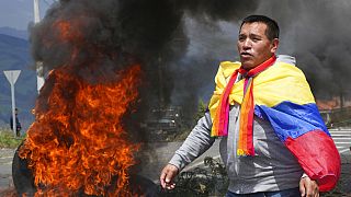 A protester draped with an Ecuadorean flag