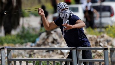 متظاهر يلقي حجرا في اتجاه قوات إسرائيلية خلال مظاهرة قرب بيت لحم في الضفة الغربية المحتلة