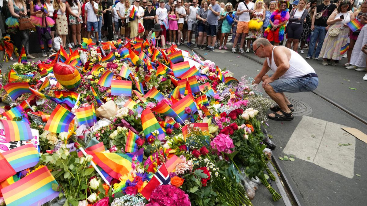 Des personnes déposent des fleurs sur les lieux d'une fusillade près d'un club gay dans le centre d'Oslo, en Norvège, samedi 25 juin 2022. 