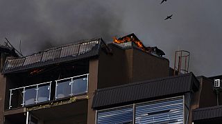 Des oiseaux survolent un immeuble résidentiel après des explosions, à Kyiv, en Ukraine, dimanche 26 juin 2022.