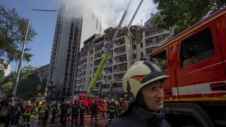 Спасатели разбирают завалы в доме, пострадавшем от ракетного удара по Киеву 26 июня 2022