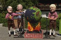 Disfrazados con cabezas gigantes, un grupo de activistas protesta contra los líderes del G7 simulando asar el planeta Tierra