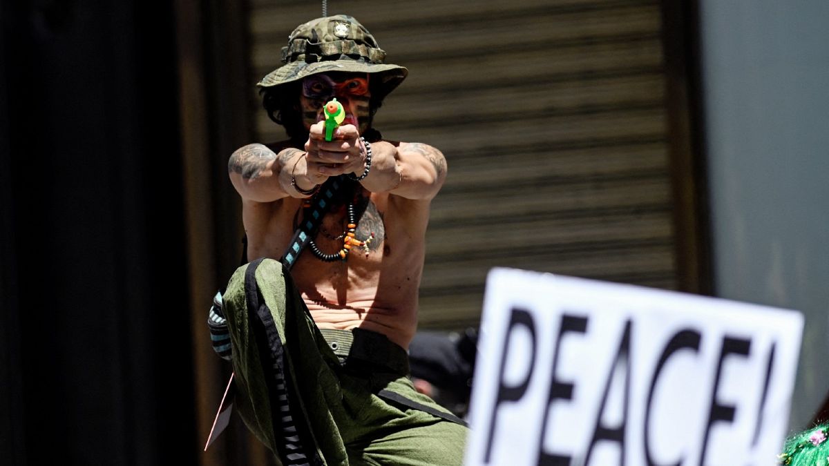 An activist with a water gun takes part in an anti-NATO demonstration in downtown Madrid on June 26, 2022.