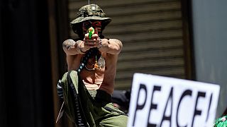 An activist with a water gun takes part in an anti-NATO demonstration in downtown Madrid on June 26, 2022.