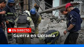 Trabajadores de búsqueda y rescate y residentes locales sacan un cadáver de debajo de los escombros de un edificio tras el ataque aéreo ruso en Lisichansk, región de Lugansk