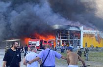 Πολίτες παρακολουθούν από απόσταση την πυρκαγιά και τους καπνούς από το εμπορικό κέντρο που δέχτηκε πυραυλικό χτύπημα στο Κρεμεντσούκ