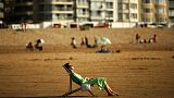 Egy nő napozik a belgiumi Knokke-Heist strandján 2020 július 31-én