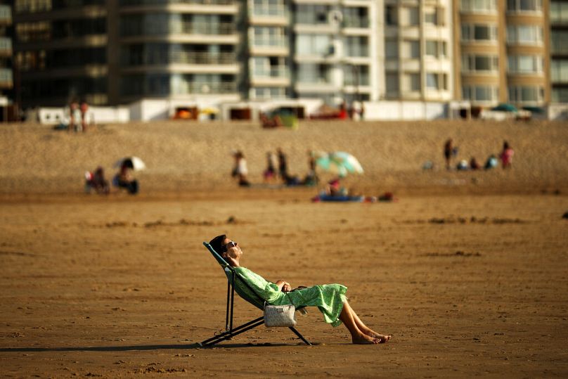 Mulher toma banhos de sol durante um dia quente de verão na praia de Zoute em Knokke-Heist, no norte da Bélgica, sexta-feira, 31 de julho de 2020