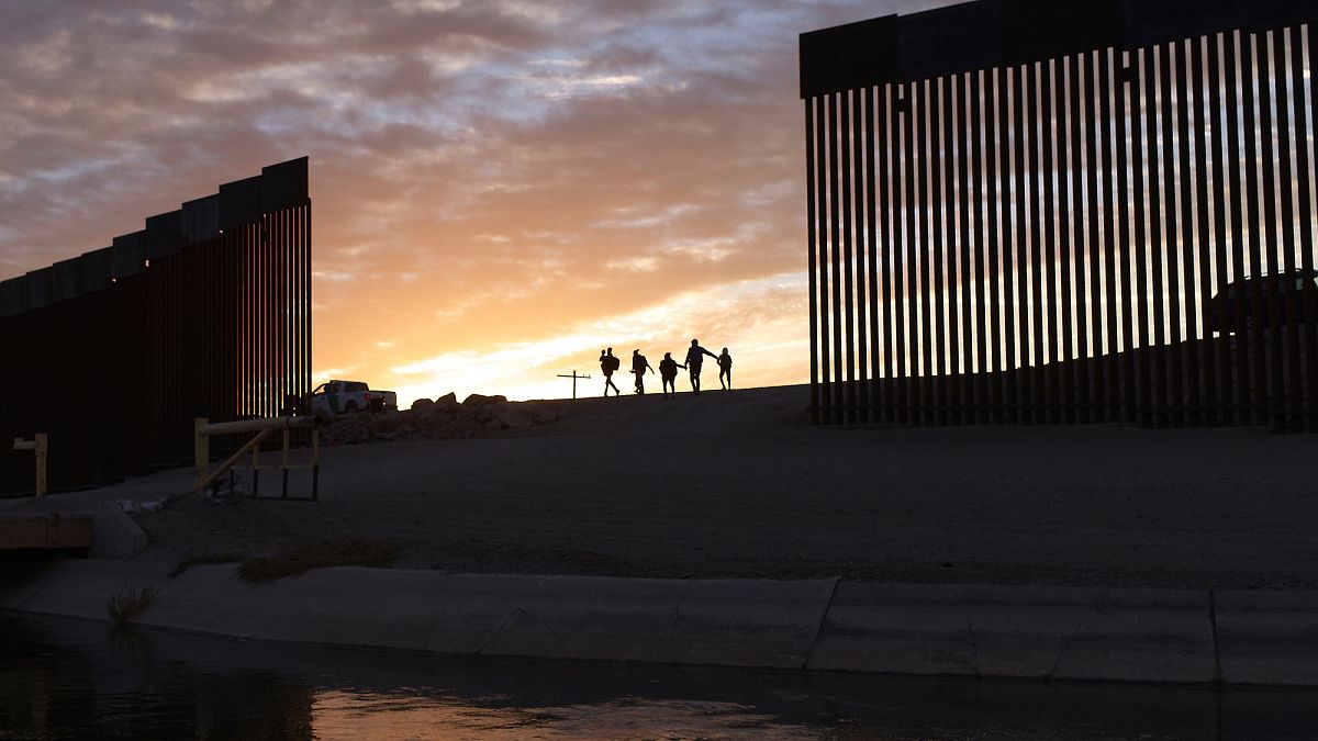 Arizona eyaletinin Yuma bölgesinde bulunan sınır duvarından geçen Meksikalı bir aile