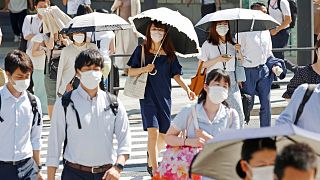 Son 150 yılın en sıcak haziran ayının yaşandığı Japonya'nın başkenti Tokyo'da halk, aşırı sıcaklardan korunmak için şemsiye kullandı