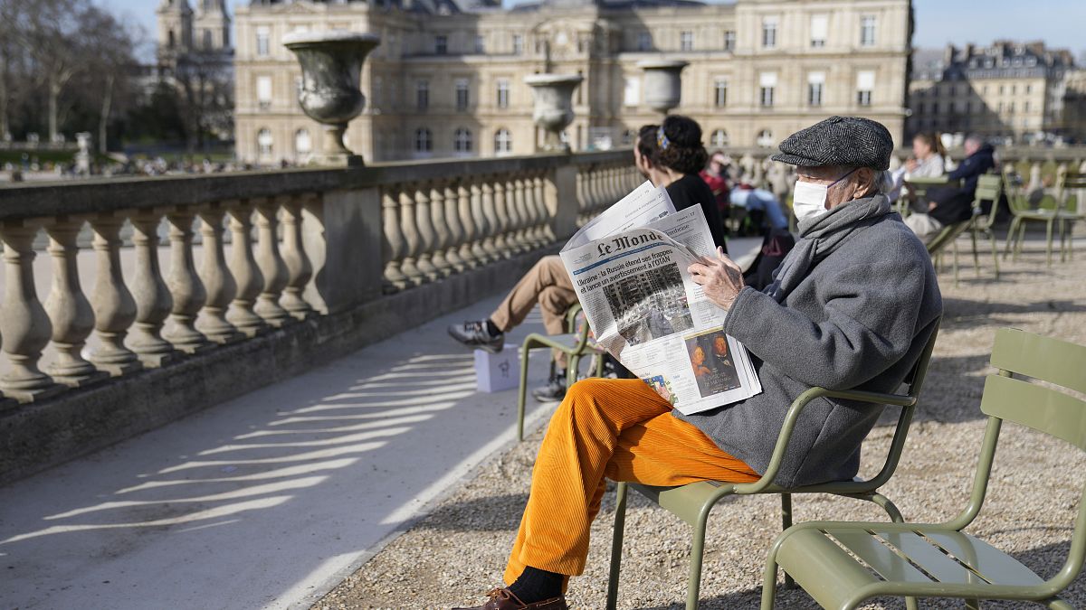 رجل يرتدي الكمامة ويقرأ الصحيفة في باريس - فرنسا - أرشيف