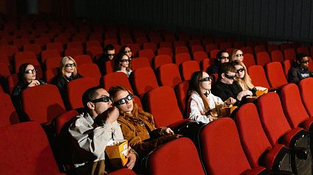 A crowd enjoy a 3D film at the cinema