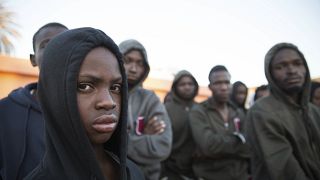 طفل مالي ومهاجرون آخرون بعد أن أنقذهم خفر السواحل قبالة الساحل الليبي.